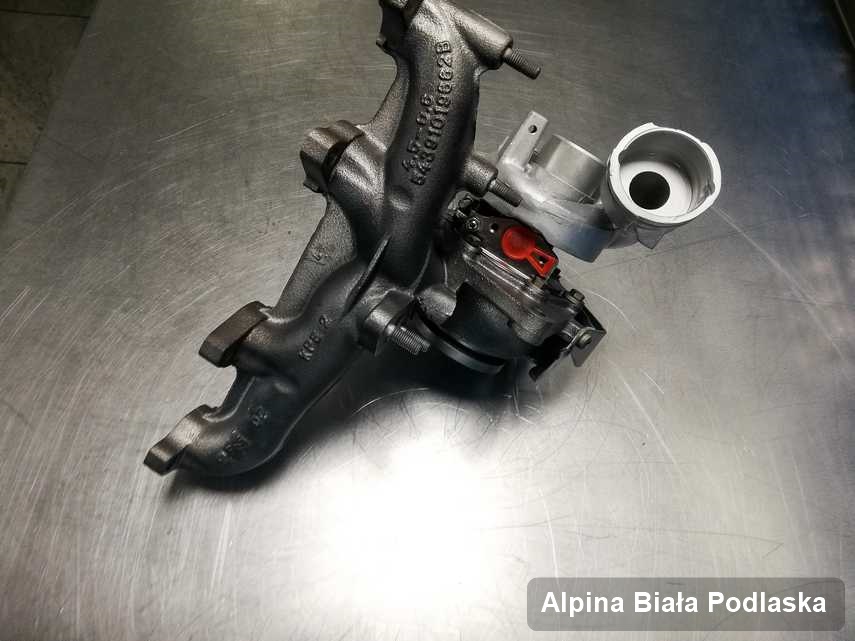 Zregenerowana w firmie w Białej Podlaskiej turbosprężarka do aut  firmy Alpina na stole w laboratorium po naprawie przed wysyłką