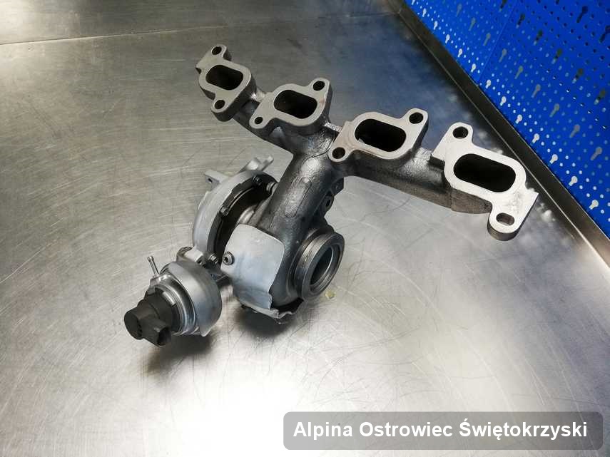 Wyczyszczona w laboratorium w Ostrowcu Świętokrzyskim turbosprężarka do samochodu marki Alpina na stole w pracowni po remoncie przed wysyłką