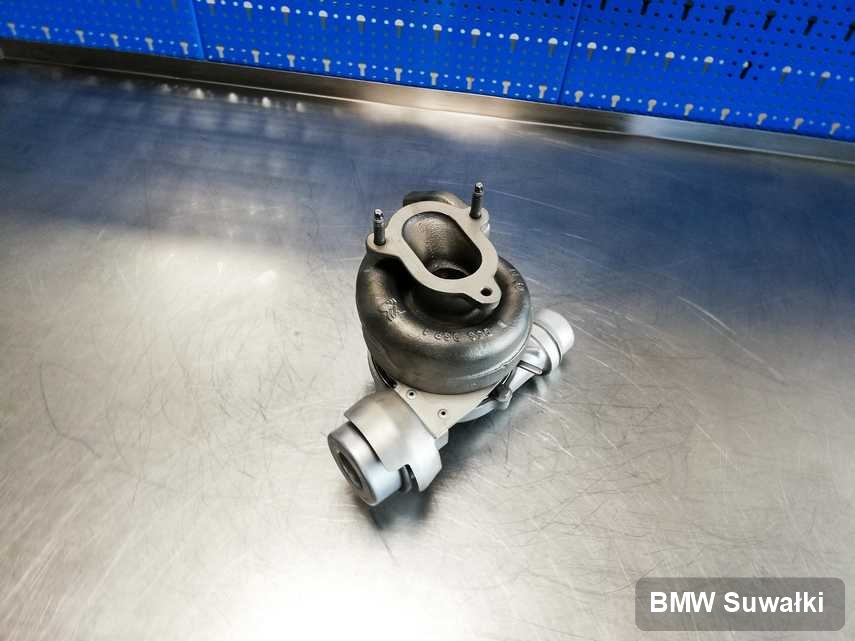Naprawiona w pracowni w Suwałkach turbosprężarka do samochodu z logo BMW na stole w pracowni wyremontowana przed nadaniem