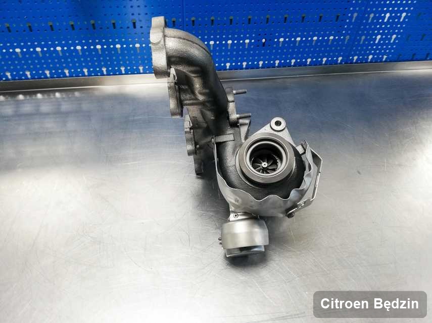 Wyczyszczona w pracowni regeneracji w Będzinie turbosprężarka do aut  firmy Citroen na stole w laboratorium naprawiona przed wysyłką