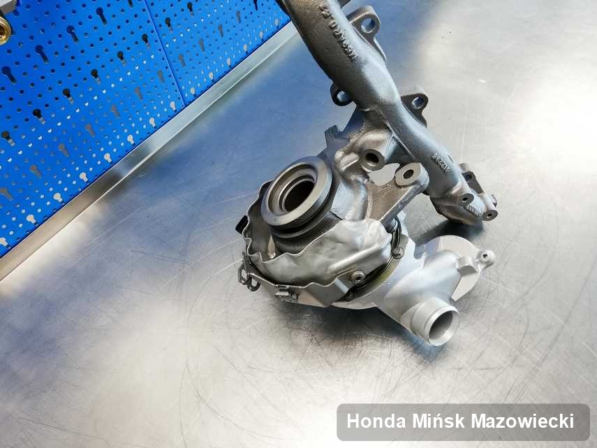 Wyczyszczona w przedsiębiorstwie w Mińsku Mazowieckim turbosprężarka do aut  z logo Honda na stole w pracowni po remoncie przed nadaniem