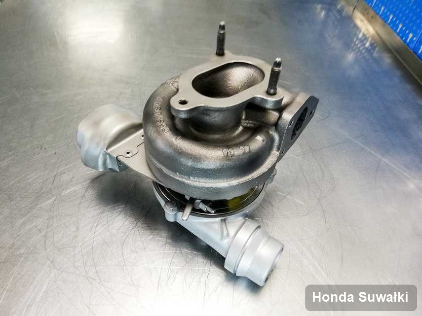 Zregenerowana w laboratorium w Suwałkach turbosprężarka do aut  z logo Honda na stole w laboratorium naprawiona przed wysyłką