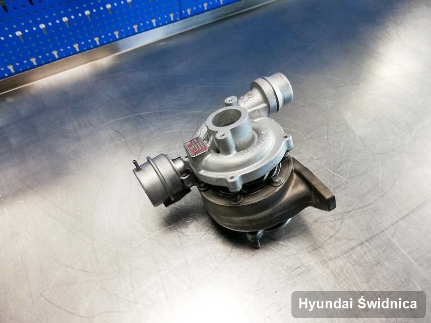 Wyremontowana w przedsiębiorstwie w Świdnicy turbosprężarka do samochodu z logo Hyundai na stole w laboratorium wyremontowana przed wysyłką