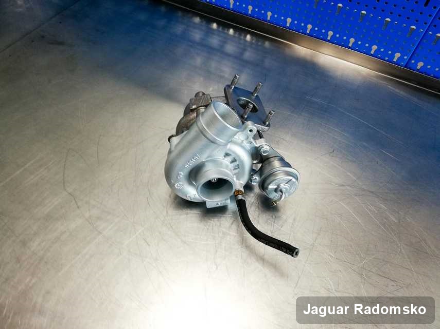Naprawiona w przedsiębiorstwie w Radomsku turbosprężarka do aut  z logo Jaguar na stole w warsztacie po remoncie przed nadaniem