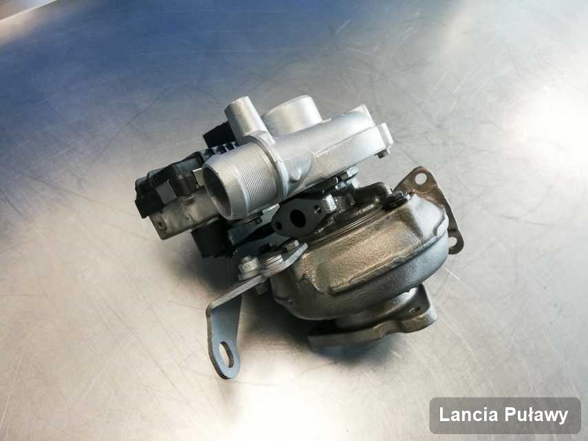 Naprawiona w pracowni w Puławach turbosprężarka do samochodu z logo Lancia na stole w laboratorium naprawiona przed wysyłką