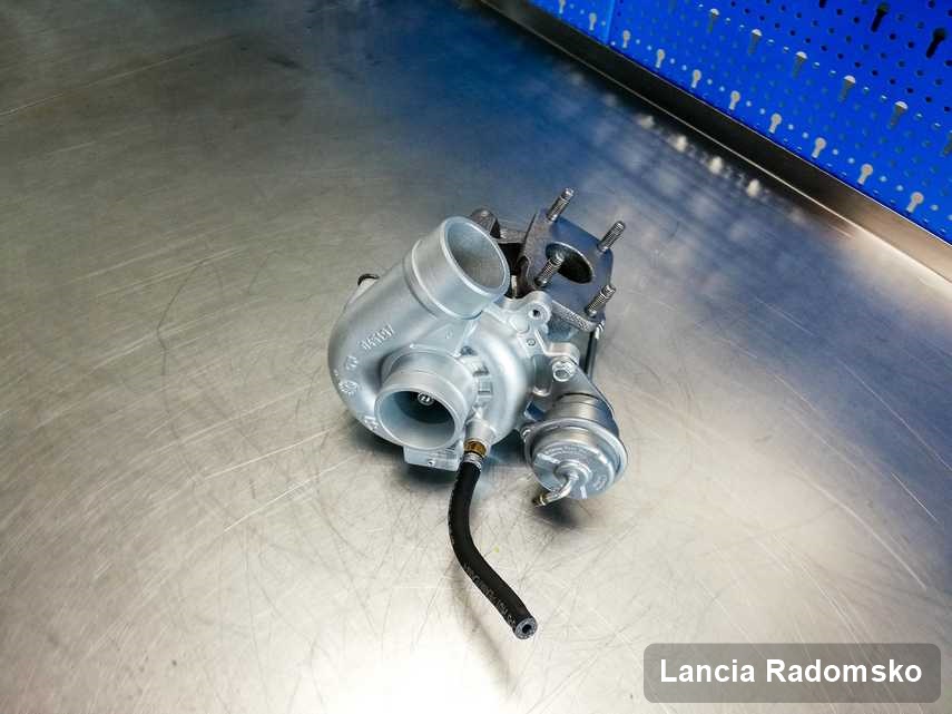 Zregenerowana w pracowni regeneracji w Radomsku turbosprężarka do osobówki z logo Lancia na stole w pracowni naprawiona przed nadaniem