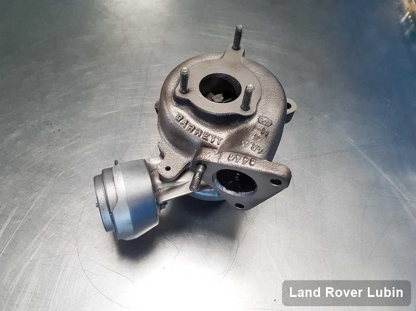 Naprawiona w pracowni w Lubinie turbosprężarka do aut  z logo Land Rover na stole w warsztacie wyremontowana przed spakowaniem