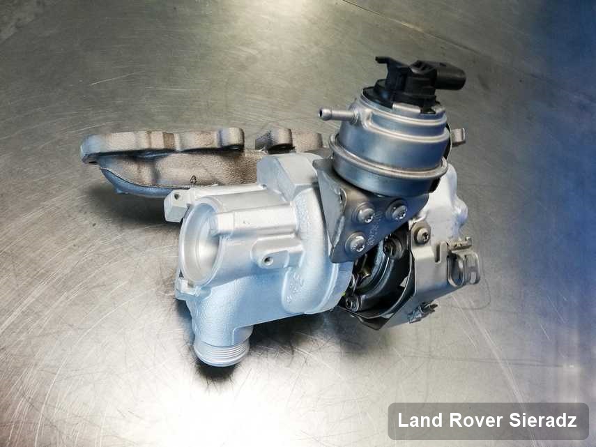 Wyremontowana w pracowni w Sieradzu turbosprężarka do pojazdu z logo Land Rover na stole w pracowni po regeneracji przed wysyłką