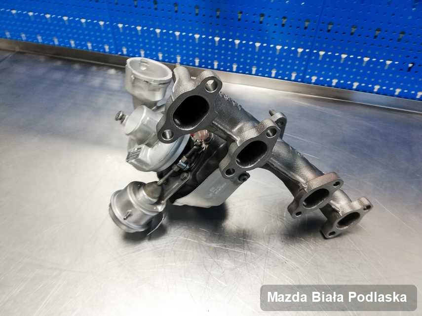 Wyczyszczona w przedsiębiorstwie w Białej Podlaskiej turbosprężarka do aut  marki Mazda na stole w pracowni po regeneracji przed wysyłką