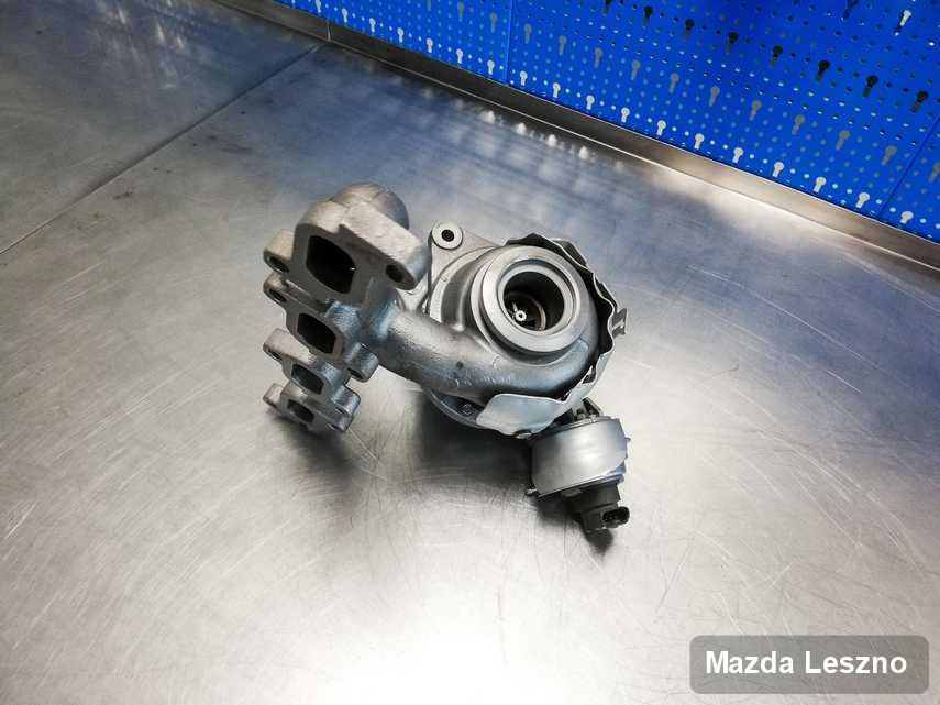 Naprawiona w pracowni regeneracji w Lesznie turbosprężarka do samochodu spod znaku Mazda na stole w laboratorium po remoncie przed nadaniem