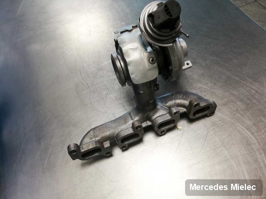 Wyremontowana w firmie w Mielcu turbosprężarka do auta z logo Mercedes na stole w pracowni po regeneracji przed spakowaniem