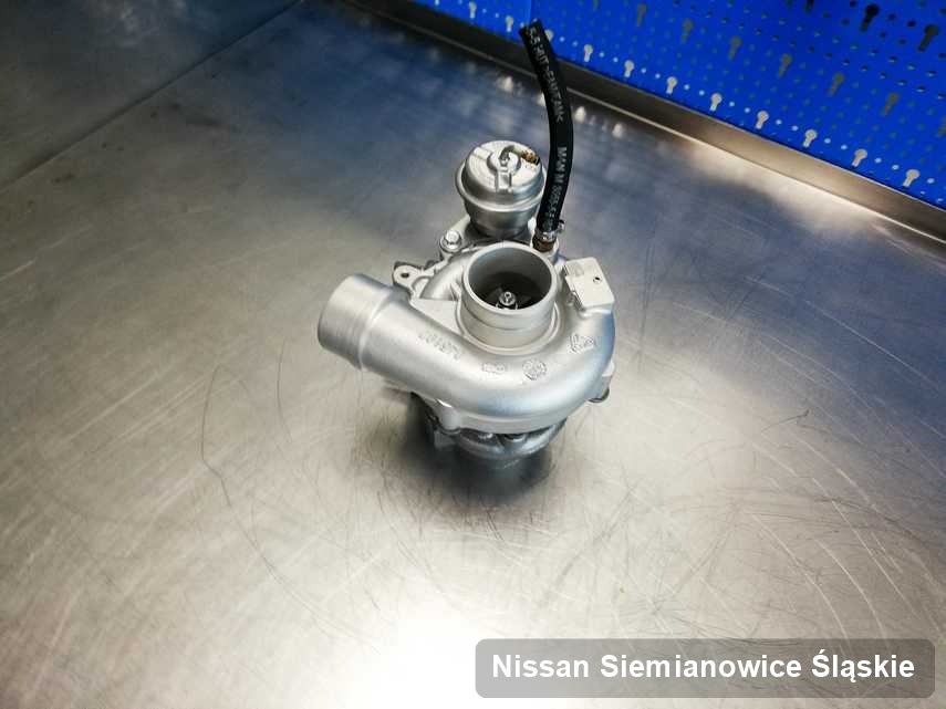 Naprawiona w przedsiębiorstwie w Siemianowicach Śląskich turbosprężarka do pojazdu z logo Nissan na stole w warsztacie po remoncie przed wysyłką