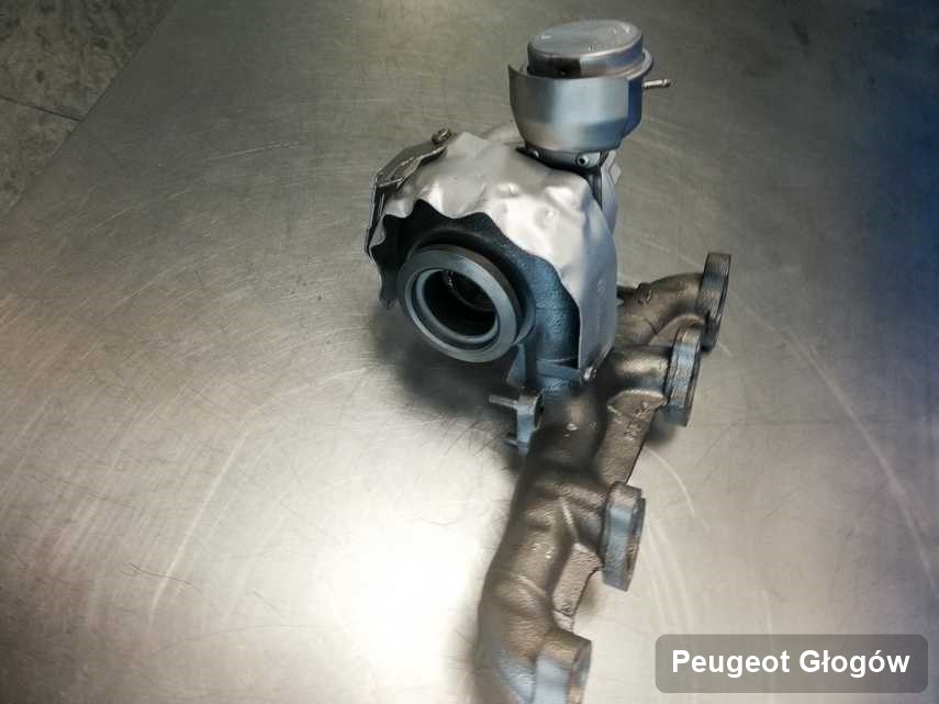 Zregenerowana w przedsiębiorstwie w Głogowie turbosprężarka do auta firmy Peugeot na stole w laboratorium po remoncie przed wysyłką
