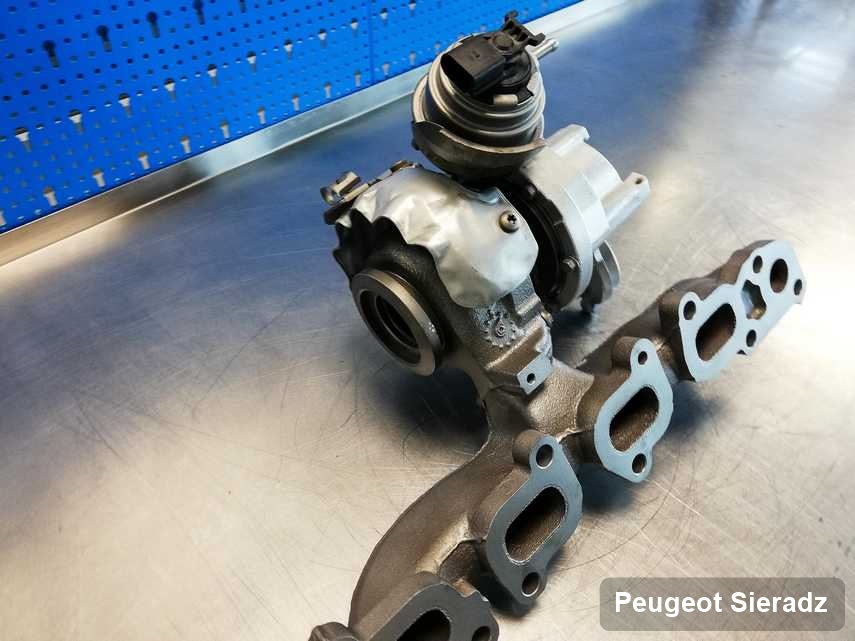 Naprawiona w pracowni regeneracji w Sieradzu turbosprężarka do samochodu z logo Peugeot przygotowana w laboratorium po regeneracji przed wysyłką