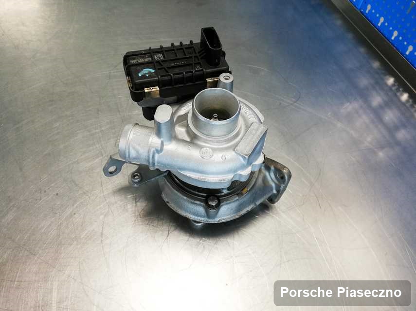 Naprawiona w laboratorium w Piasecznie turbosprężarka do pojazdu z logo Porsche na stole w pracowni po remoncie przed nadaniem