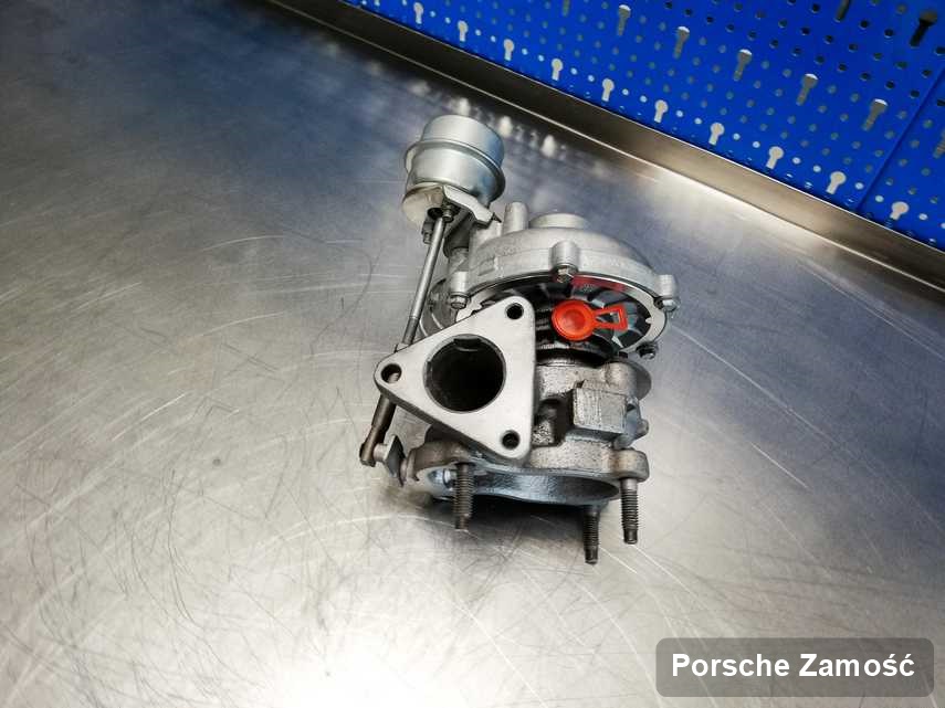 Zregenerowana w przedsiębiorstwie w Zamościu turbosprężarka do osobówki z logo Porsche na stole w pracowni po naprawie przed spakowaniem