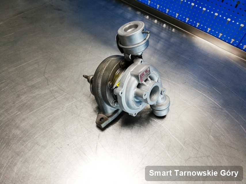 Zregenerowana w pracowni regeneracji w Tarnowskich Górach turbosprężarka do osobówki z logo Smart na stole w laboratorium po regeneracji przed wysyłką
