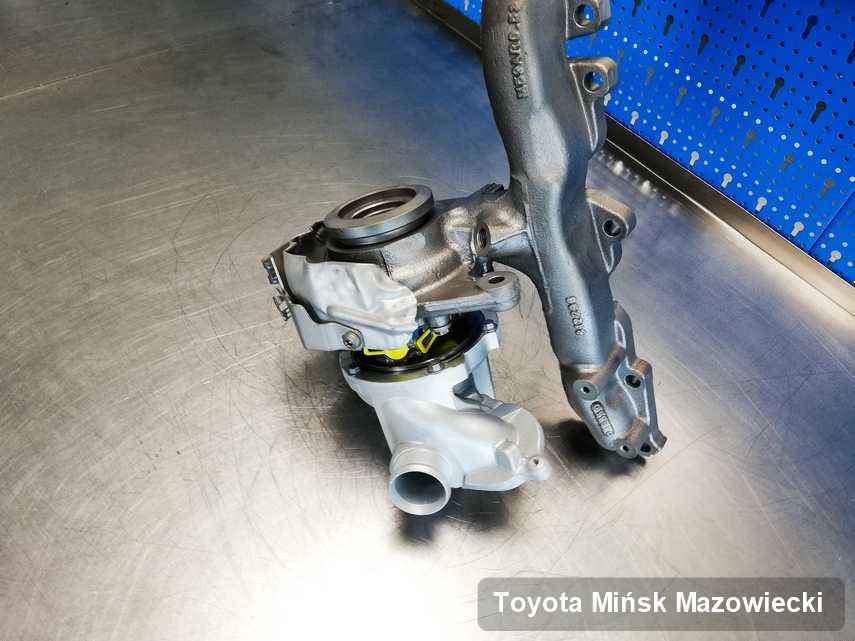 Wyczyszczona w przedsiębiorstwie w Mińsku Mazowieckim turbosprężarka do auta z logo Toyota na stole w laboratorium po naprawie przed wysyłką